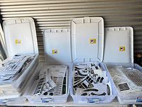 Five plastic bins opened, each filled with sticker sheets