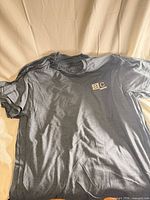 Stack of grey T-shirts showing front design and fabric color