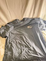 Stack of gray Gildan T-shirts showing front with logo