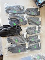 Ten bagged pairs and one unbagged pair of North Aware black leather gloves with tags