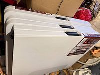 Three folded 6-ft tables stacked upright, showing carry handles