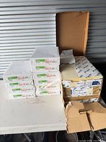 Stack of eight pink Domtar Pastel Colors Opaque reams beside three yellow Nexfor Worx Offset Opaque reams