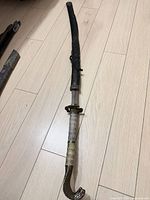 Full view of sword in sheath showing overall length and cobra-head pommel