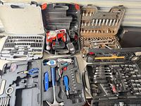 Five open tool cases on table showing full assortment