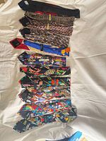 Fifteen colorful ties laid flat showing full assortment