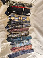 Full set of 17 neckties laid out on white cloth
