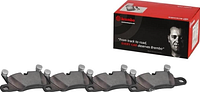 Box and four Brembo brake pads laid out