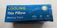 Top of retail box showing product name Cooling Thin Pillow Memory Foam