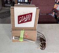 Front view showing Schlitz logo panel, clock section with taped loose hands, power cord