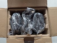 Speakers wrapped in plastic inside cardboard box