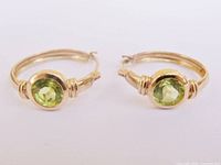 Front view of both hoop earrings showing peridot gemstones and gold setting