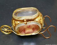 Full view of casket showing cart frame, wheel and handles