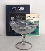 Footed glass bowl in front of two Canadian glass reference books