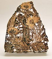 Front view showing entire pierced copper design with rabbit and floral elements