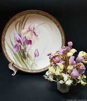 Plaque front with iris design beside glass bouquet