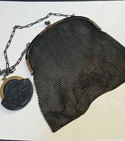 Full view of gunmetal mesh handbag with attached small leather coin purse