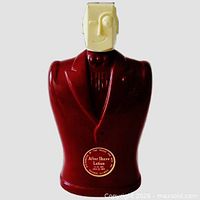 Front view of burgundy glass torso bottle with cream cubist stopper and gold label