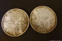 Front view of both 1962 and 1965 silver dollars showing Voyageur design