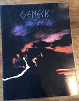 Front view of folded Genesis poster showing cover artwork and dotted logo