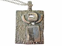 Front view of textured brutalist pendant with eye and perforated panel detail