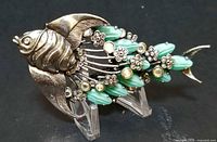 full view of brooch left side showing fish form and embellishments