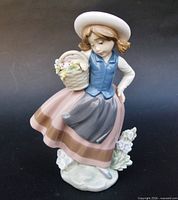 Front view of Lladró figurine showing girl, basket, and floral base