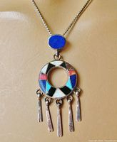 Front view of pendant on chain showing gemstone inlay and dangles