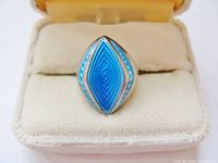 Front view of aquamarine guilloché enamel ring in velvet box
