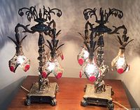 Full view of both ornate metal lamps lit on tabletop