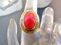 Front view of ring showing oval red glass cabochon set in brass bezel with silver-tone solder