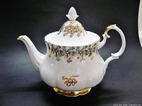 Right side view of teapot showing handle, spout and commemorative inscription