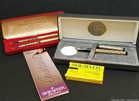 Group view: Sheaffer pen in case, Chanel pair in red case, cartridge box, instruction flyer visible