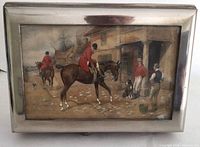 Top view of chrome humidor lid with English hunt scene under glass