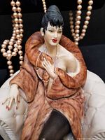 Front view of porcelain lady figurine on chair with hanging pearl strands