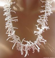 Front view of white branch coral necklace on display bust