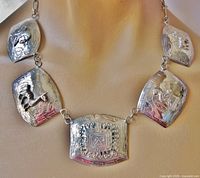Front view of five-panel silver-tone bib necklace displayed on bust