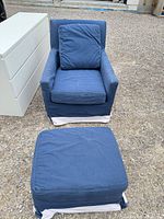 Blue upholstered armchair and ottoman with white skirt trim