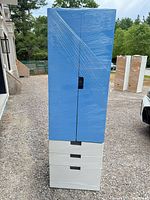Front view of tall blue and white wardrobe, shrink-wrapped