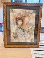 Front view of framed mixed media portrait artwork in gilt frame