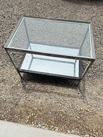 Full view of coffee table showing glass top and mirrored shelf