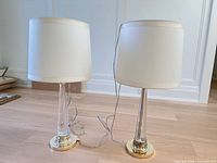 Front view of both lamps showing shades, glass columns, bases