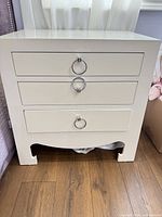 Front view of white 3-drawer nightstand