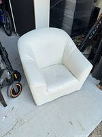 Front and side view of children’s white faux leather barrel chair
