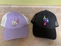 Front view of both hats showing colours, mesh backs and embroidered patches
