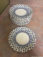 Stack of twelve saucers showing top floral pattern