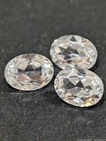 Three oval clear stones on dark background