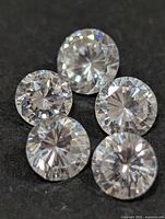 Five round cubic zirconia stones on dark background