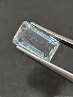 Rectangular aquamarine held in tweezers showing top view