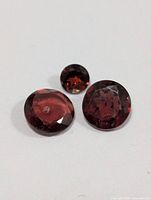 close-up of three loose garnet stones