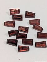 Loose faceted garnet stones arranged on white background